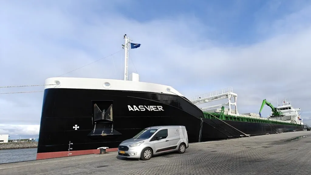 Bow of hybrid cargo vessel Aasvaer moored at the quay with a Marble Automation van